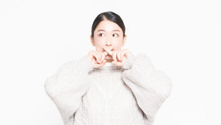 指でバツ印をつくる女性