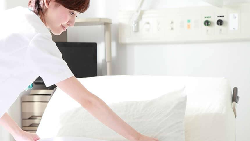 ベットメイクをする介護士