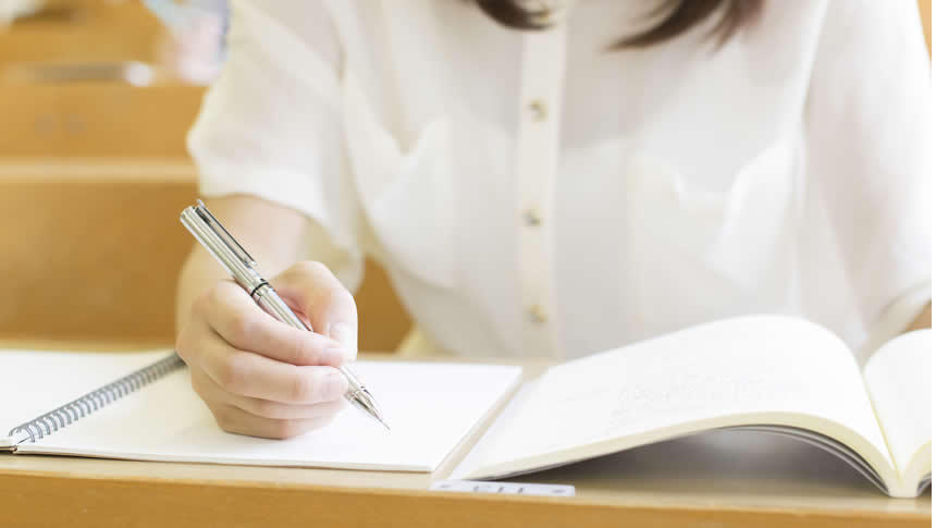 ノートにメモを取る女性