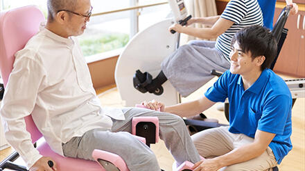 高齢者の運動補助をする男性