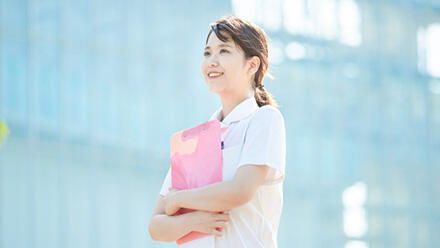 ファイルを胸に微笑む女性