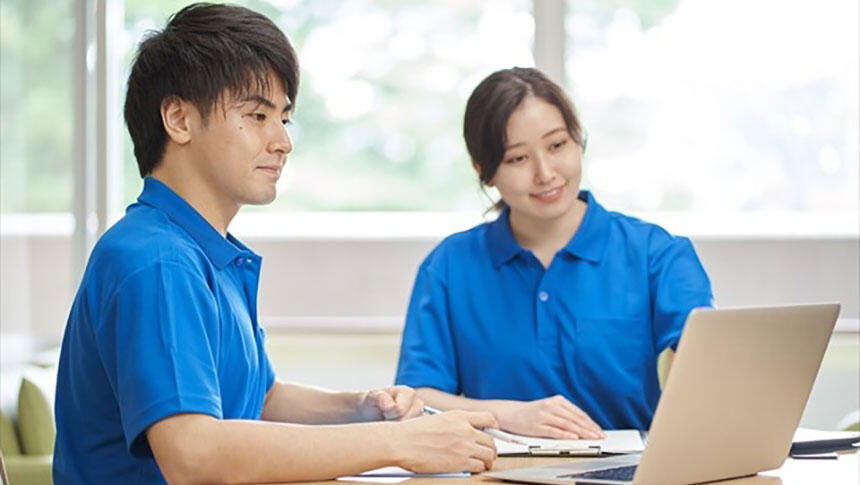 デスクワークをする男女の介護職