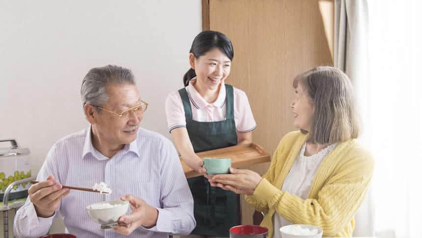 料理を配膳する介護士