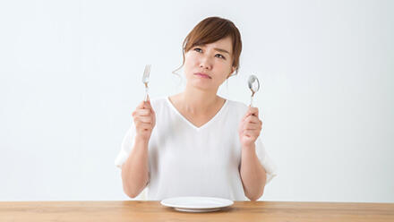 スプーンとフォークを持つ女性
