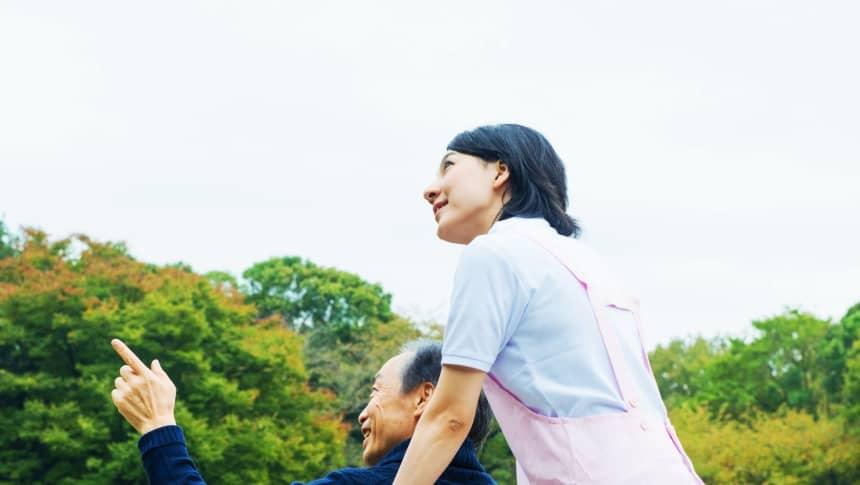 空を見上げる介護士と利用者
