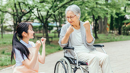 ガッツポーズで見つめあう利用者と介護職